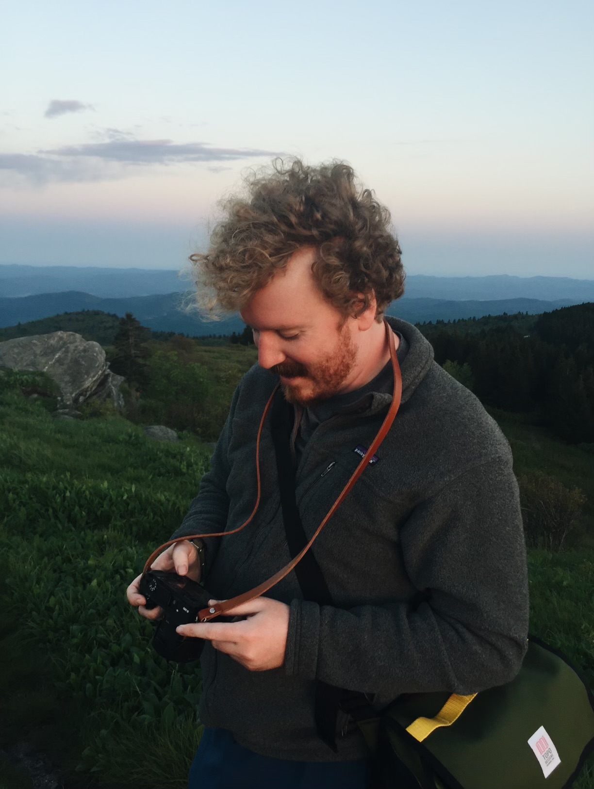 Aaron on a mountain with a camera